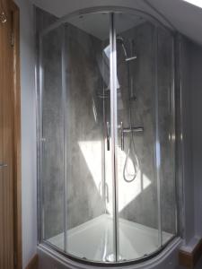 a shower with a glass door in a bathroom at Ha'penny Acre in Sherfield English