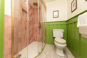 a green bathroom with a toilet and a shower at Escape Boutique B&B in Llandudno