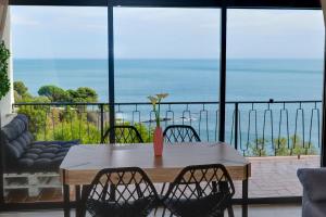 una mesa y sillas con vistas al océano en apartamento deluxe cau del llop en Llança