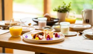 a table with a plate of food and glasses of orange juice at Corona Dolomites Hotel in Andalo