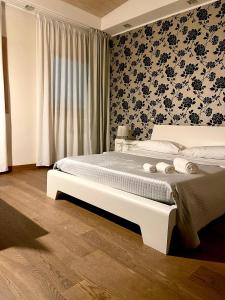 a bedroom with a large bed with black and white wallpaper at Baia Di Ognina in Catania