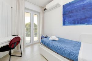 um quarto com uma cama, uma secretária e uma janela em MGH Family Stay - Costa DOro Superior Apartment em Sirmione
