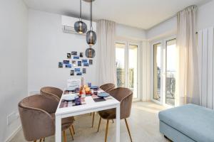 uma sala de jantar com uma mesa branca e cadeiras em MGH Family Stay - Costa DOro Superior Apartment em Sirmione