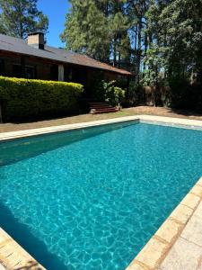 a blue swimming pool in front of a house at Avalon in Esquina