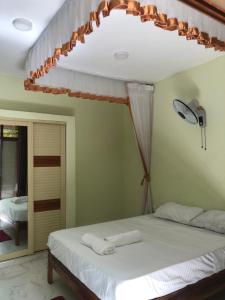 una camera con letto bianco e specchio di KwetuNyumbani away from Home a Mombasa