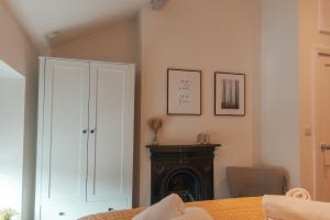 een kamer met een witte kast en een tafel bij Bridge Apartment in Stockport