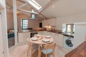 a kitchen with a table and chairs in a kitchen at Bridge Apartment in Stockport