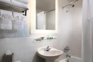 a white bathroom with a sink and a mirror at Catamaran Resort Hotel and Spa in San Diego