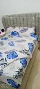 a bed with blue and white comforter and pillows at Luxury Appartement, en plein centre in Kenitra