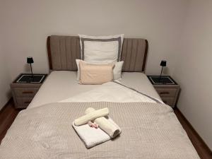 ein Bett mit einem Handtuch und einem Telefon darauf in der Unterkunft Appartement Schwetzingerstadt in Mannheim