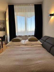 a large bed in a bedroom with a large window at City Apartment am Ku'damm & ICC Messe/Free Parking in Berlin