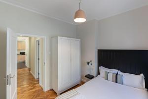 - une chambre avec un grand lit et une tête de lit noire dans l'établissement Aliados 3 Bed apartment, à Porto