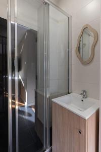 La salle de bains est pourvue d'un lavabo et d'une douche. dans l'établissement Aliados 3 Bed apartment, à Porto