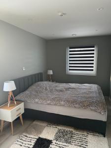 ein Schlafzimmer mit einem großen Bett und einem Fenster in der Unterkunft Eksluzywny apartament w zaciszu in Kristiansund