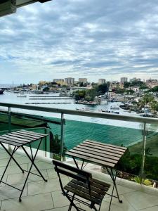 a balcony with two chairs and a view of a harbor at Baia Di Ognina in Catania