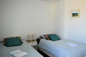 two beds sitting next to each other in a bedroom at Entre Plage et Ports, Le 49 - avec balcon 4 étoiles in Courseulles-sur-Mer