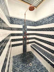 une salle de bain avec douche aux carreaux bleus et blancs dans l'établissement Livin Right Sail Loft: pickleball, basketball, close 2 the fun!, à Fort Walton Beach