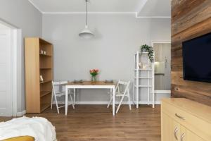Elite Apartments Stare domki في غدانسك: غرفة معيشة مع طاولة وغرفة طعام