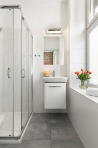 Elite Apartments Stare domki في غدانسك: حمام أبيض مع دش ومغسلة