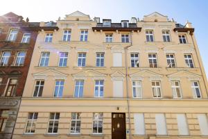 Elite Apartments Stare domki في غدانسك: مبنى أصفر كبير مع الكثير من النوافذ