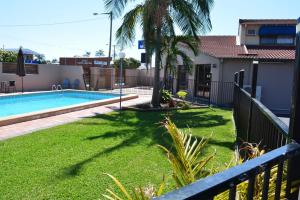 a yard with a swimming pool and a house at Alabaster Motor Inn in Taree