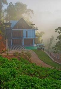 una casa en una colina en la niebla con un parque infantil en Wenasa Villa en Diyatalawa