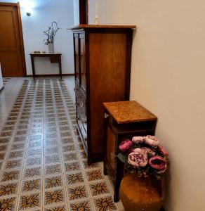 un couloir avec une table, une armoire et des fleurs dans l'établissement Casa Anselmo Guest House, à Pagani