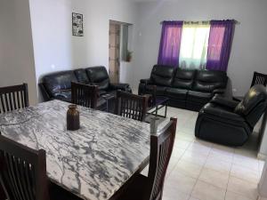 un soggiorno con tavolo e mobili in pelle di Casa Tchitchi a São Filipe
