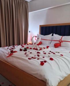 a bed with red rose petals on it with a wedding registrar at Hotel Residence Ramsis in Nador