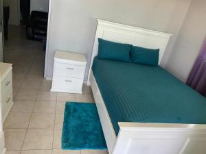 una camera da letto con un letto con cuscini blu e un tappeto di Casa Tchitchi a São Filipe