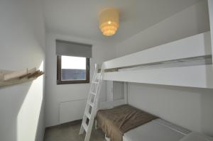 a room with a bunk bed with a ladder and a light at De witte oase 22 in Oostduinkerke