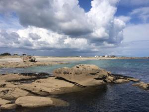 una grande roccia in acqua su una spiaggia di Bigouden Backpacker a Tréffiagat