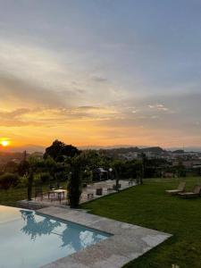 a swimming pool with a sunset in the background at Hotel Quinta da Tulha in Guimarães