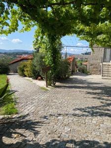 a cobblestone street with a tree frame and a building at Hotel Quinta da Tulha in Guimarães