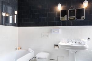 La salle de bains blanche est pourvue d'un lavabo et de toilettes. dans l'établissement Hôtel Silky by HappyCulture, à Lyon