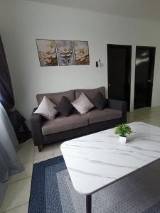 a living room with a couch and a coffee table at Cozy Nest at Coutryhomes Rawang by Bliss Stay Management in Rawang