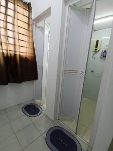 a bathroom with a shower and two blue mats on the floor at Cozy Nest at Coutryhomes Rawang by Bliss Stay Management in Rawang