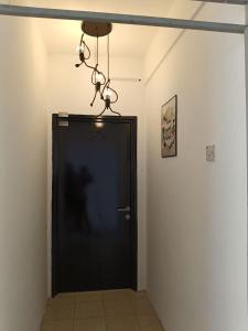 a black door with a chandelier hanging over it at Cozy Nest at Coutryhomes Rawang by Bliss Stay Management in Rawang