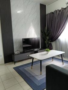a living room with a table and a tv at Cozy Nest at Coutryhomes Rawang by Bliss Stay Management in Rawang