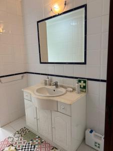 a white bathroom with a sink and a mirror at Zion Jardim Monsanto in Monsanto