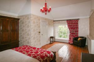 een slaapkamer met een bed, een stoel en een raam bij Preston House in Abbeyleix