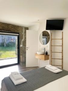 a bedroom with a bed and a sink and a mirror at Hotel Quinta da Tulha in Guimarães