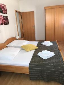 a bedroom with a bed with two towels on it at Appartementanlage Vila Anica mit schönem Pool in Barbat na Rabu