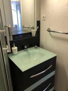 ein Bad mit einem Waschbecken und einem Spiegel in der Unterkunft SAM SUFFY in Saint-Cyr-sur-Mer