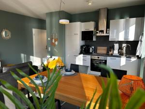 a kitchen and dining room with a wooden table at LITELIVING Cozy Suite - Sauna - Balkon - Parken - BBQ - Modern & Gemütlich in Möhnesee