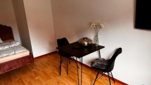 a room with a table with two chairs and a vase with flowers at Apartment 29 Marienplatz Strohberg in Stuttgart