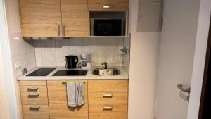 a small kitchen with a sink and a microwave at Apartment 29 Marienplatz Strohberg in Stuttgart