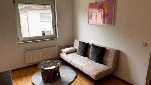 a living room with a couch and a window at Apartment 29 Marienplatz Strohberg in Stuttgart