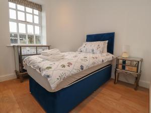 a bed with a blue headboard in a bedroom at The Lodge House in Lancaster