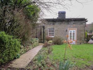 uma antiga casa de tijolos com um jardim em frente em The Lodge House em Lancaster